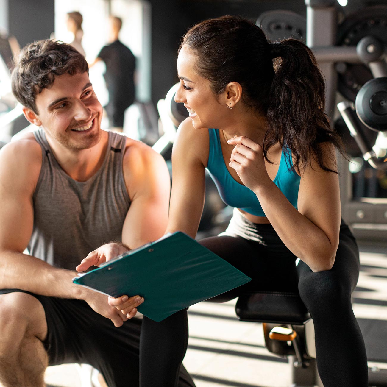 Junge Menschen im Fitnessstudio mit Tablet und Übungen